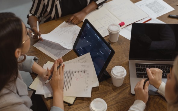 People working at table with coffee cups and laptops