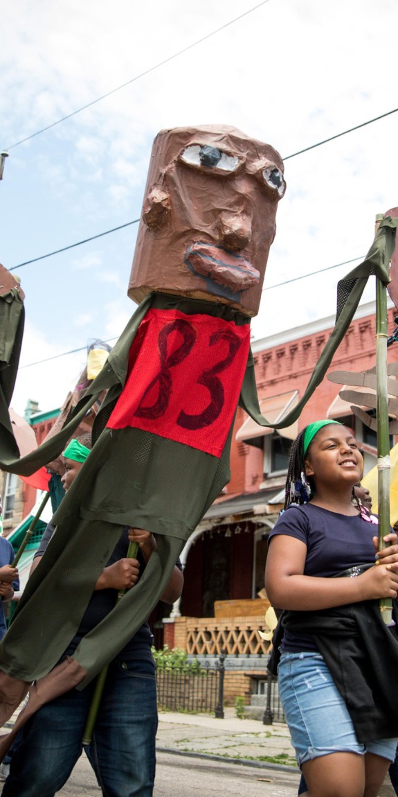 Kids walking with giant puppets