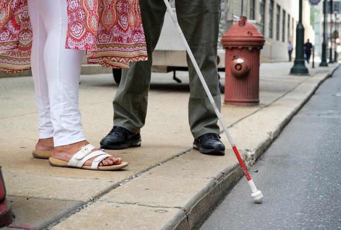 Woman with cane navigating curb