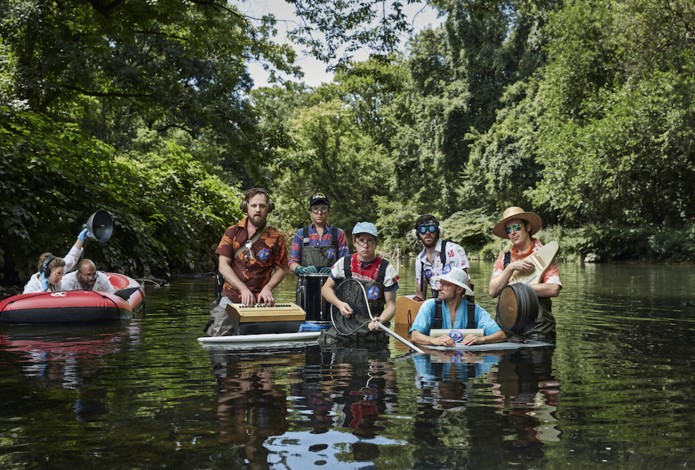 Men standing in river playing instruments